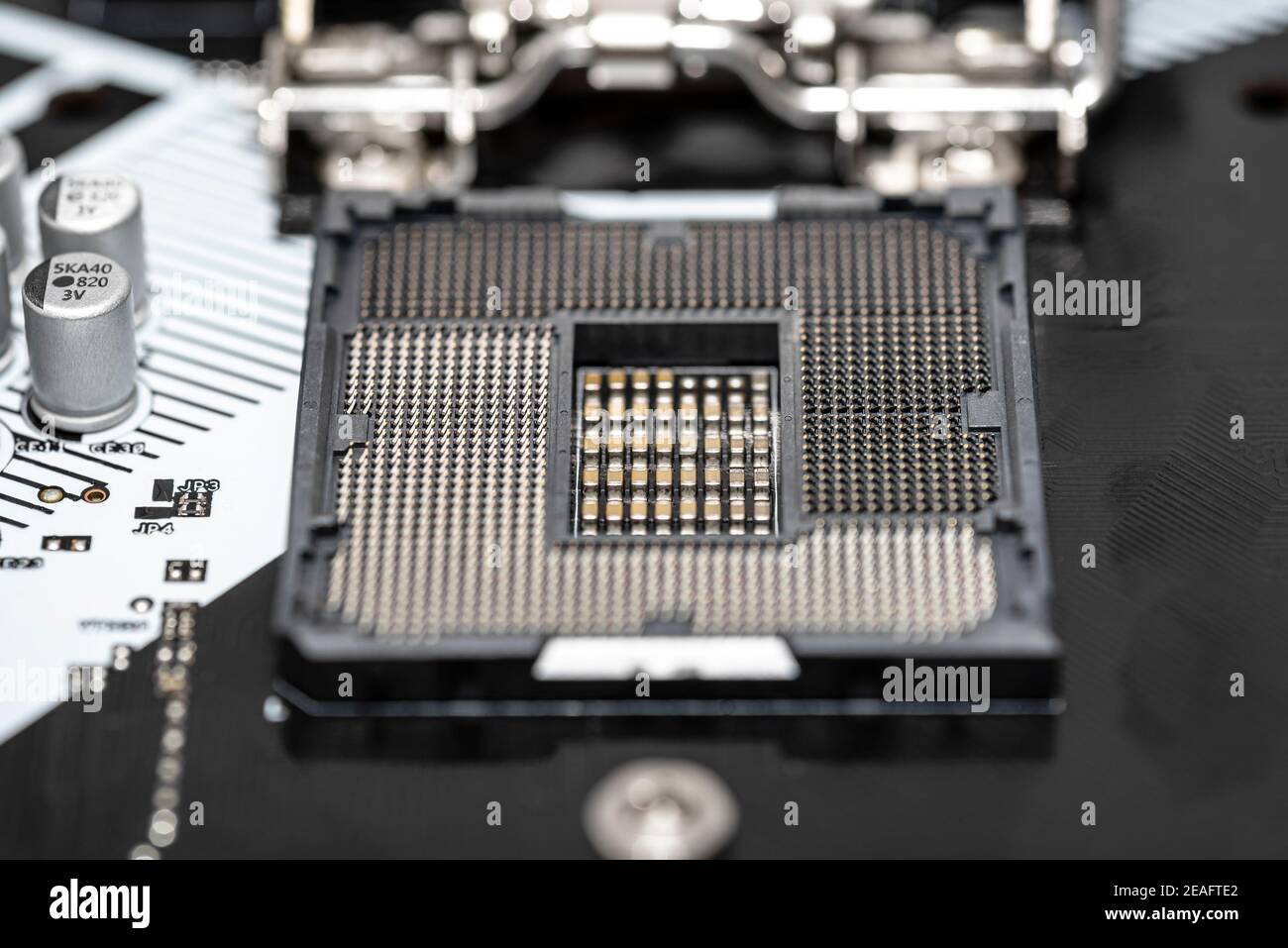 Macro shot of empty modern LGA 1200 socket for CPU on black desktop motherboard. Stock Photo