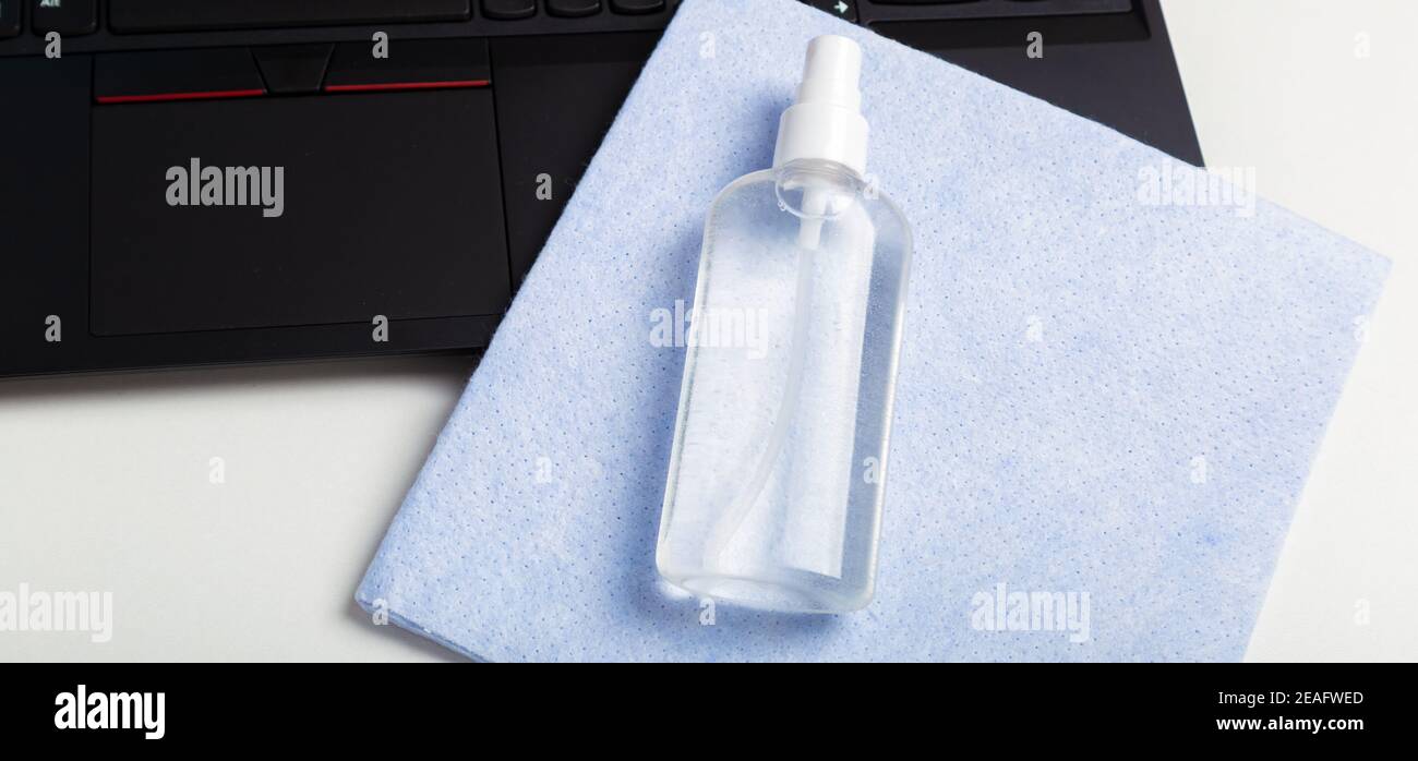 Disinfectant spray. Alcohol sanitizer on napkin cloth laptop keyboard