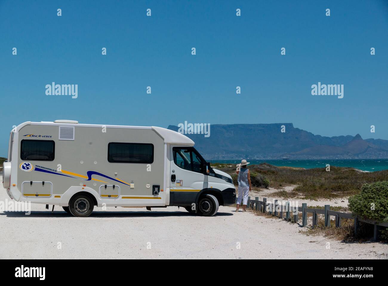Motorhome and lady stops at the World Class Blouberg Kitesurfing Beach to view Kite Surfing and its spectatular views over Cape Town's Table mountain Stock Photo