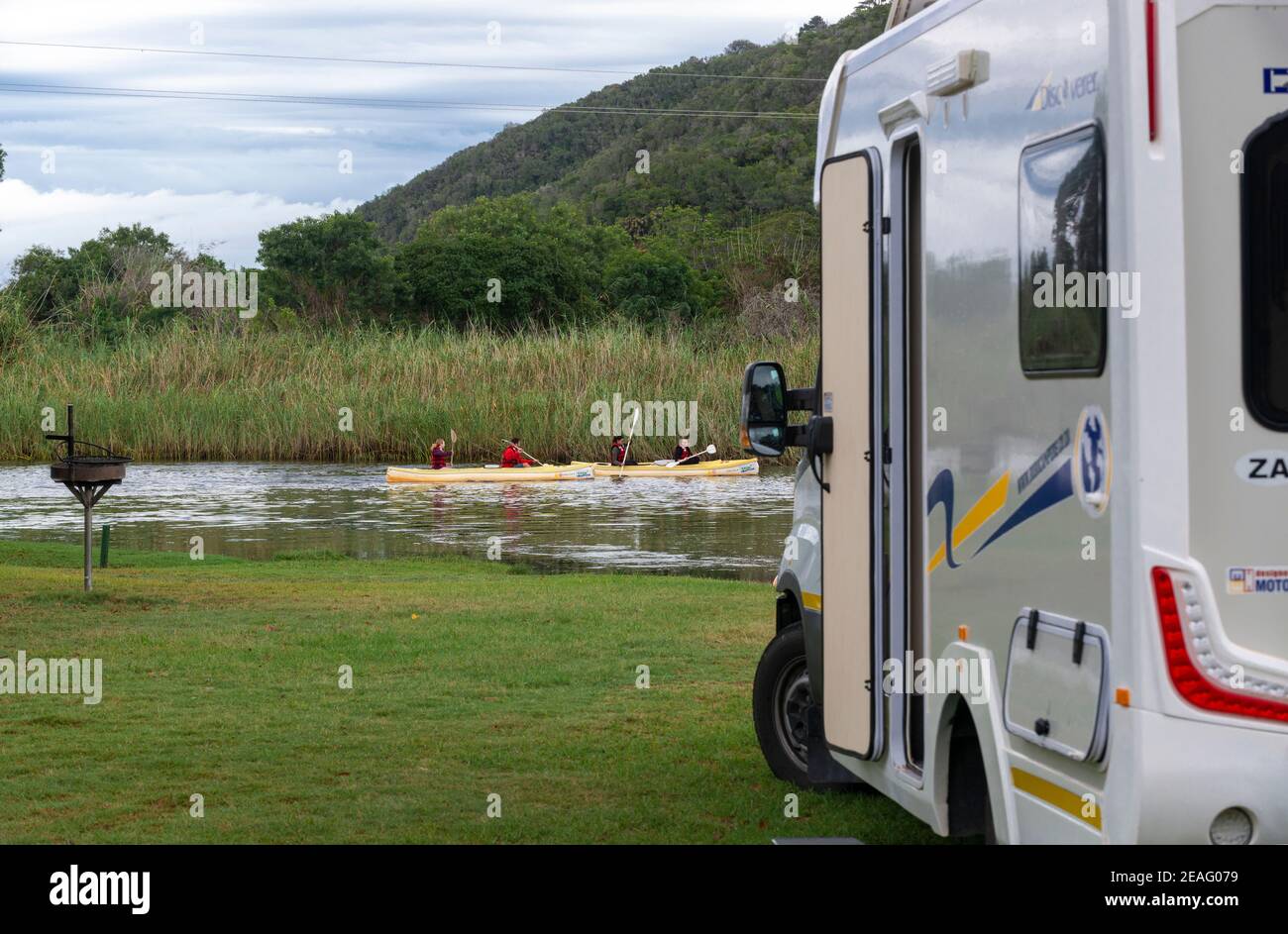 Motorhome camped by riverside  with people in canoes going by at Wilderness Ebb-and-Flow Rest Camp on the  Garden Route in South Africa Stock Photo