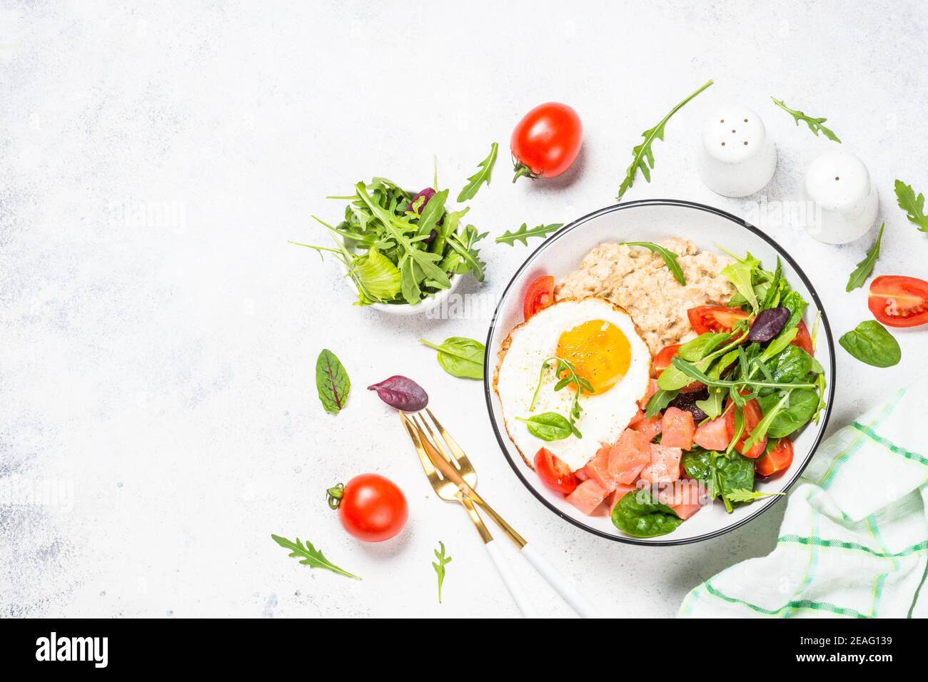 Savory breakfast with oatmeal, salmon and salad. Stock Photo