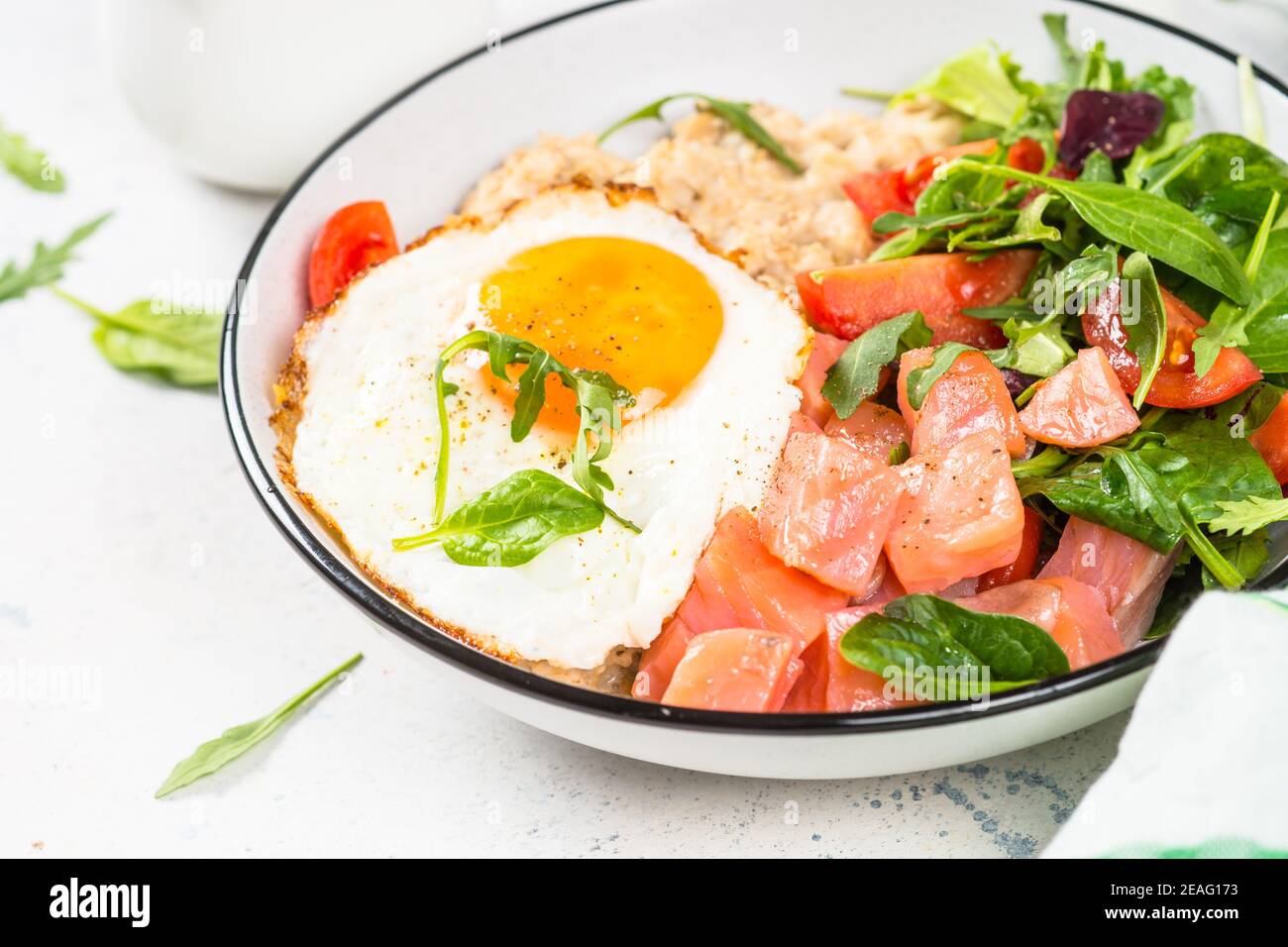 Savory breakfast with oatmeal, salmon and salad. Stock Photo