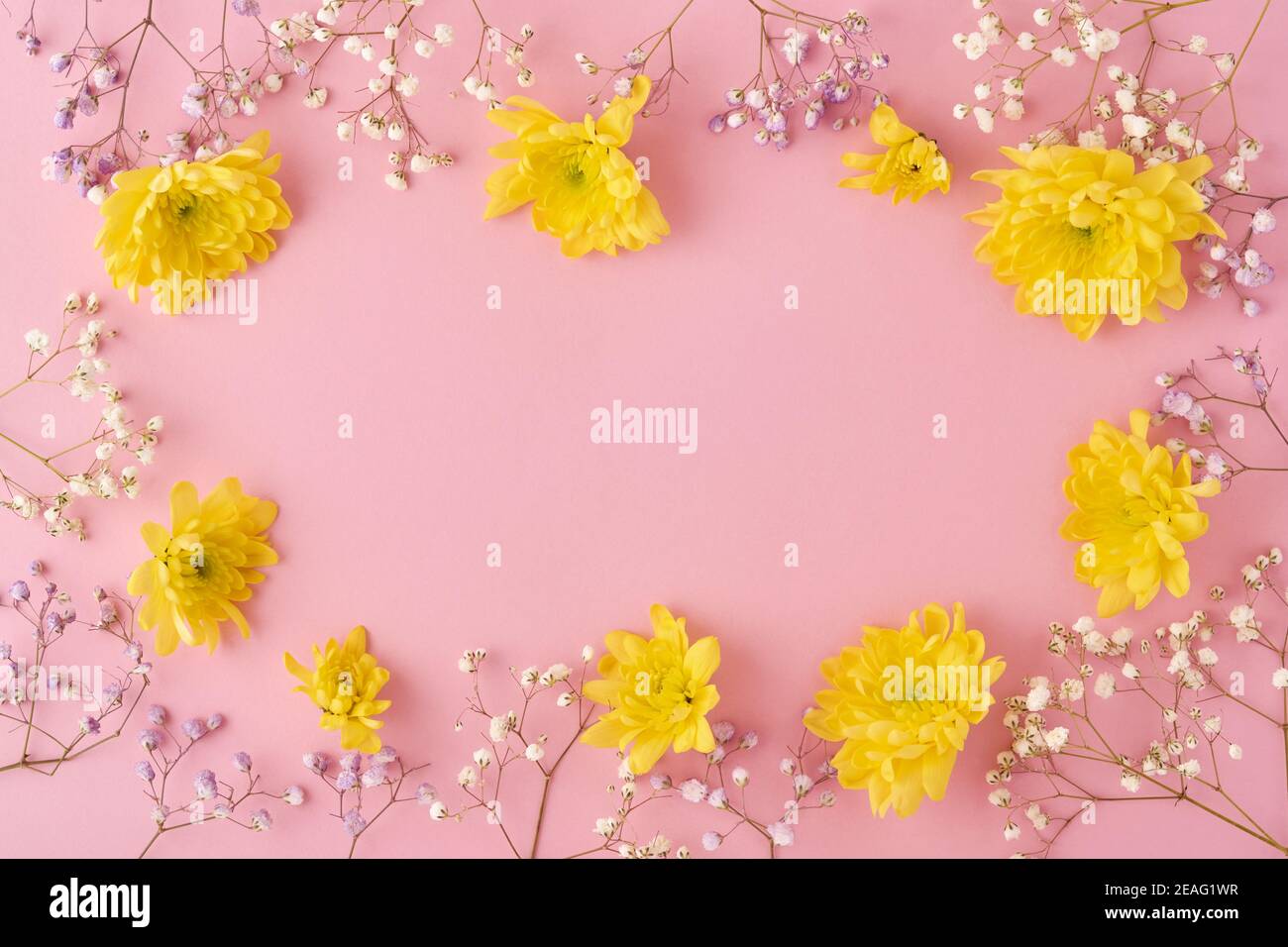 Easter concept. Eggs and yellow chrysanthemums flowers on pink background. Mock up. Spring Happy Easter holiday card. Top view. Stock Photo