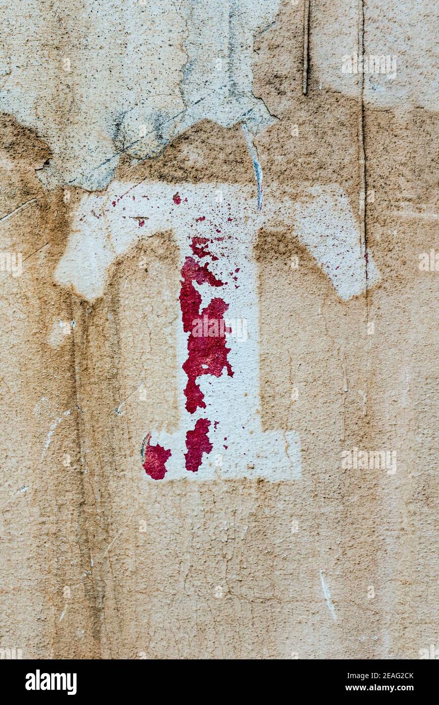 Weathered letter T with flaking red paint Stock Photo