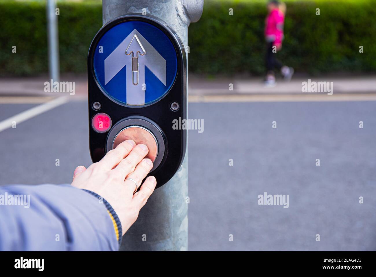 Male hand pushing button for traffic light. Use traffic lights at the crossroads. Button of the mechanism lights traffic lights on the street. System Stock Photo