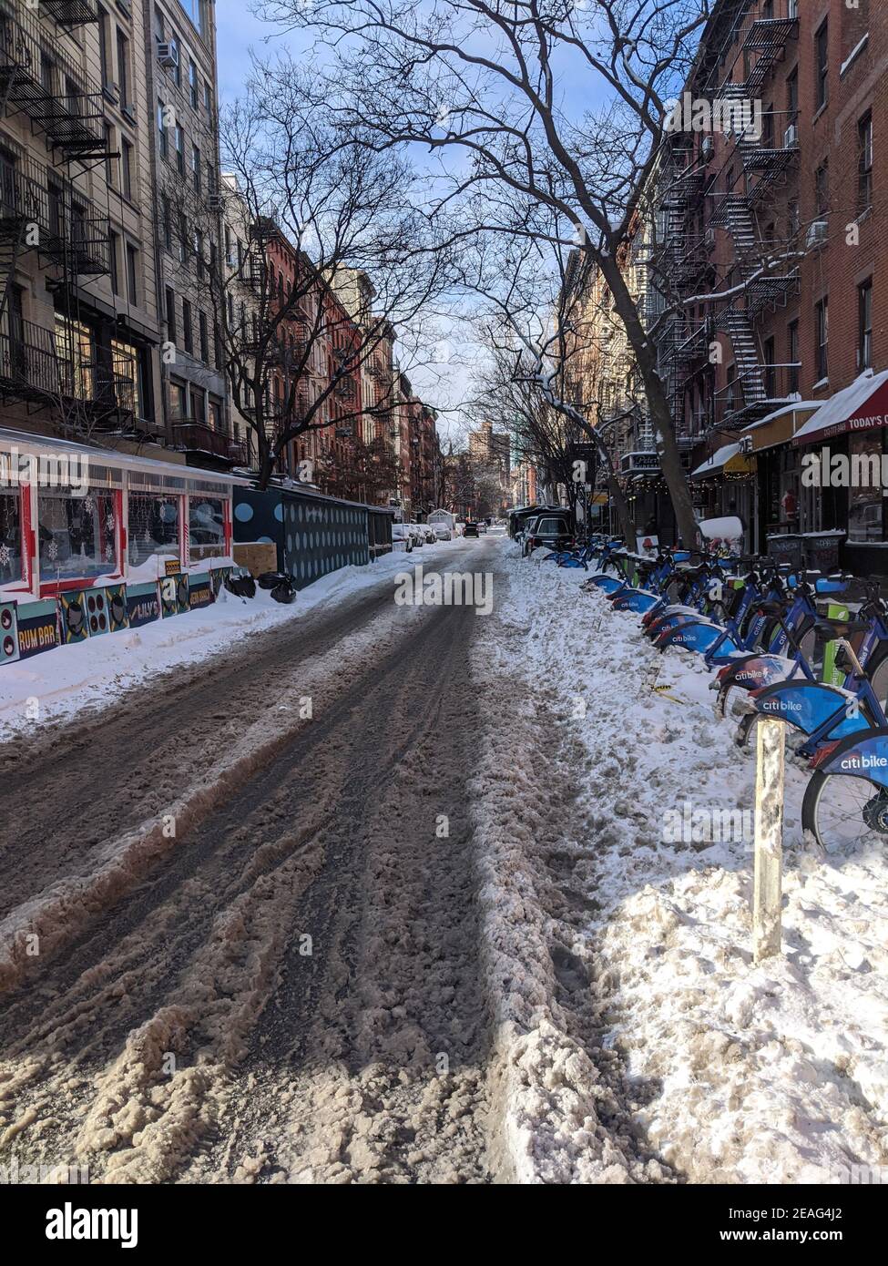 New York, USA - December 12: East Village street in Manhattan covered with pile of snow. Empty winter road with melting snow Stock Photo