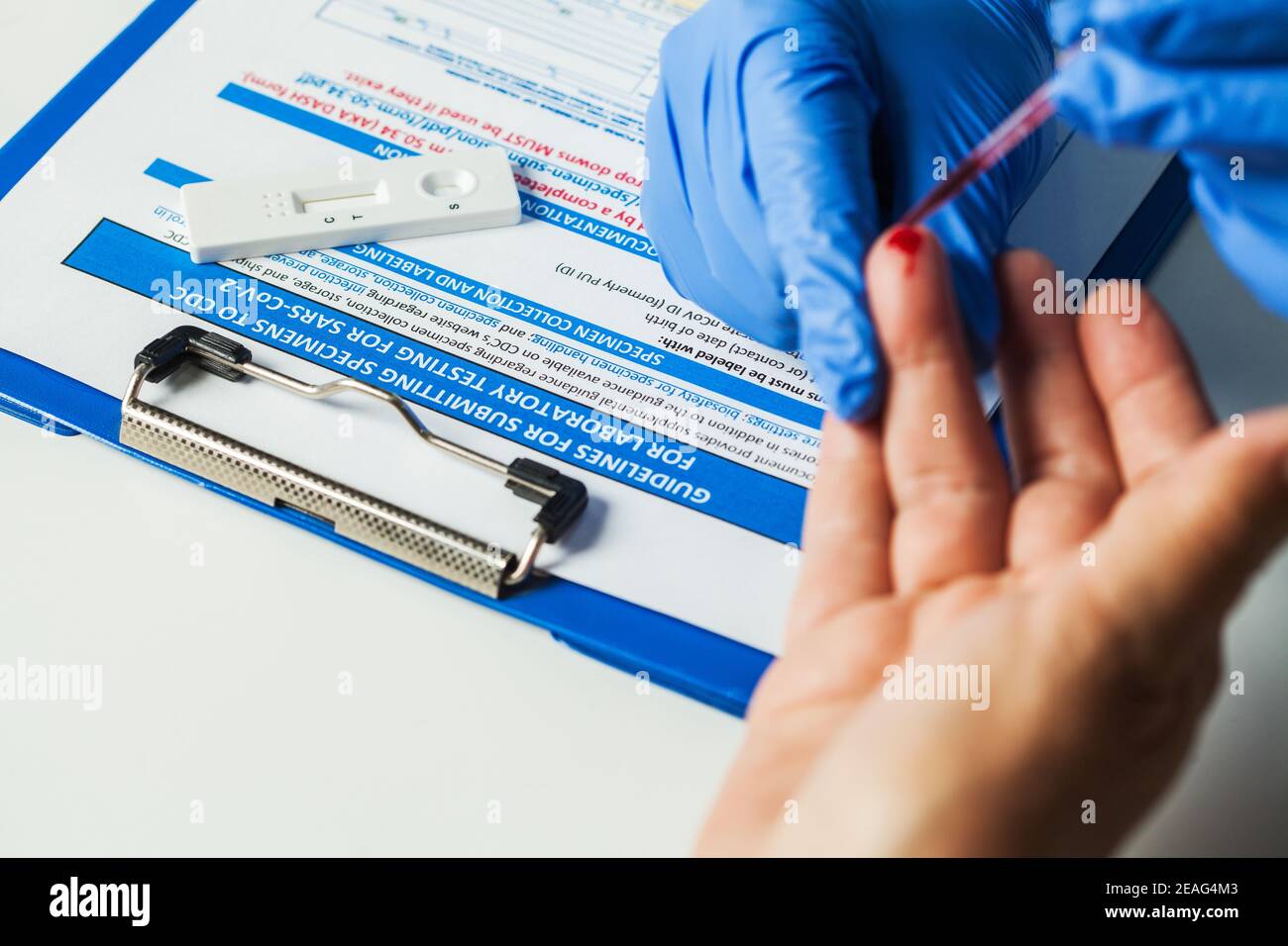 Healthcare professional performing Coronavirus COVID-19 rapid testing,fingerprick blood sample collection,point of care testing for providing same day Stock Photo