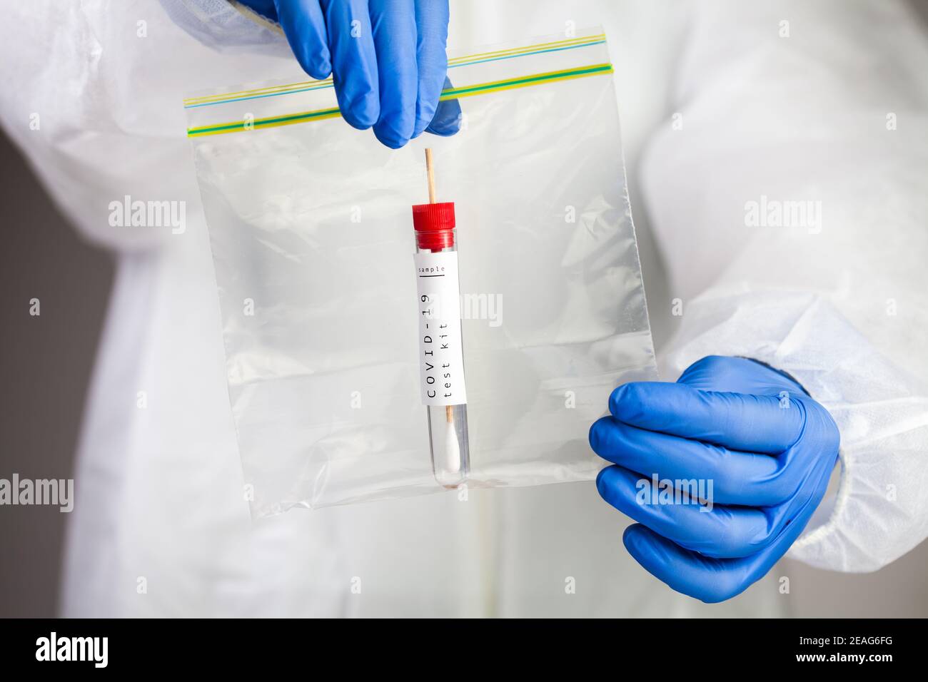 Coronavirus COVID-19 testing,swab collection equipment,sterile vacutainer with swabbing stick,closeup of hands holding a packaging bag containing spec Stock Photo