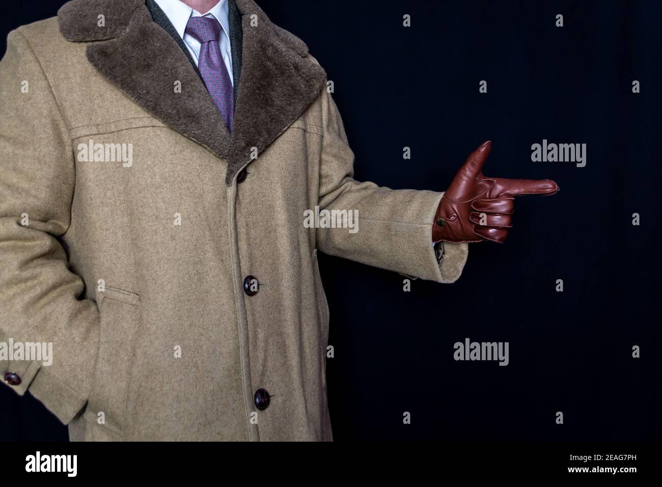 Portrait of Man in Coat and Suit with Finger Gun Gesture on Black Background. Film Noir Secret Agent Spy Hero. Detective Fighting Crime. Stock Photo