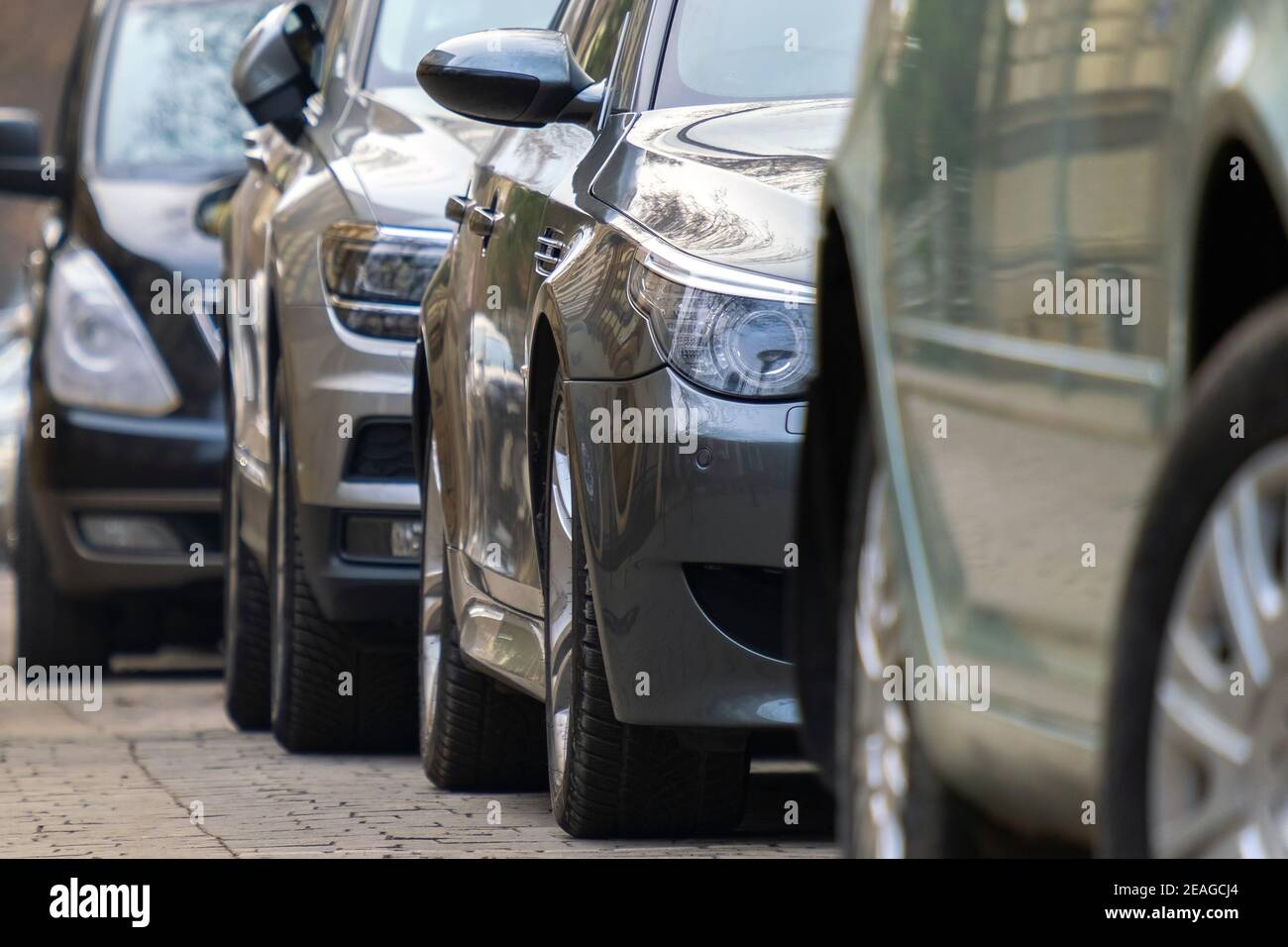 Cars parked in a row on a city street side Stock Photo - Alamy