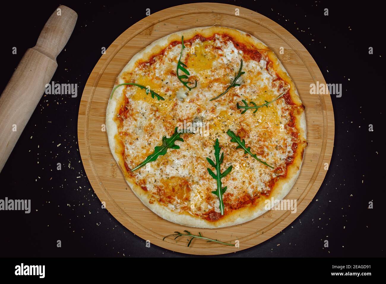 Delicious taste cheese pizza with wooden rolling pin. Classic pizza