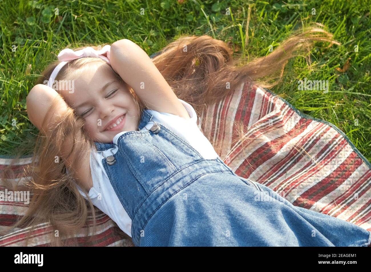 Pretty little child girl with closed eyes laying down on blanket on