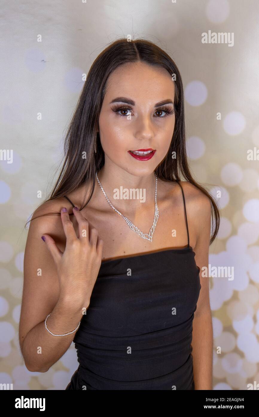 A sexy elegant woman wearing a little black dress with long brown hair and  red lipstick looking like she is ready for an elegant Christmas party or we  Stock Photo - Alamy