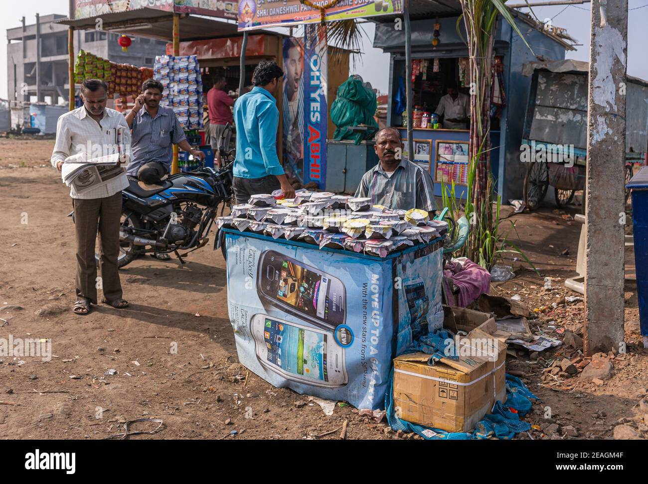 Kolhari, Karnataka, India - November 8, 2013: Roadside booth where male vendor sells home-made small cups of Chhena, a curd style resembling yoghurt t Stock Photo