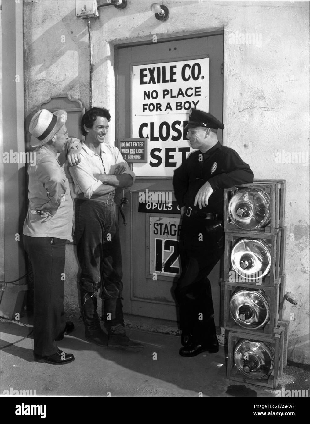 DOUGLAS FAIRBANKS Jr outside Universal Studios Sound Stage 12 with Studio Electrician MAX HARRISON and Studio Policeman JOHN WHITE behind the scenes candid during making of THE EXILE 1947 director MAX OPHULS producer Douglas Fairbanks Jr Fairbanks Company / Universal - International Stock Photo