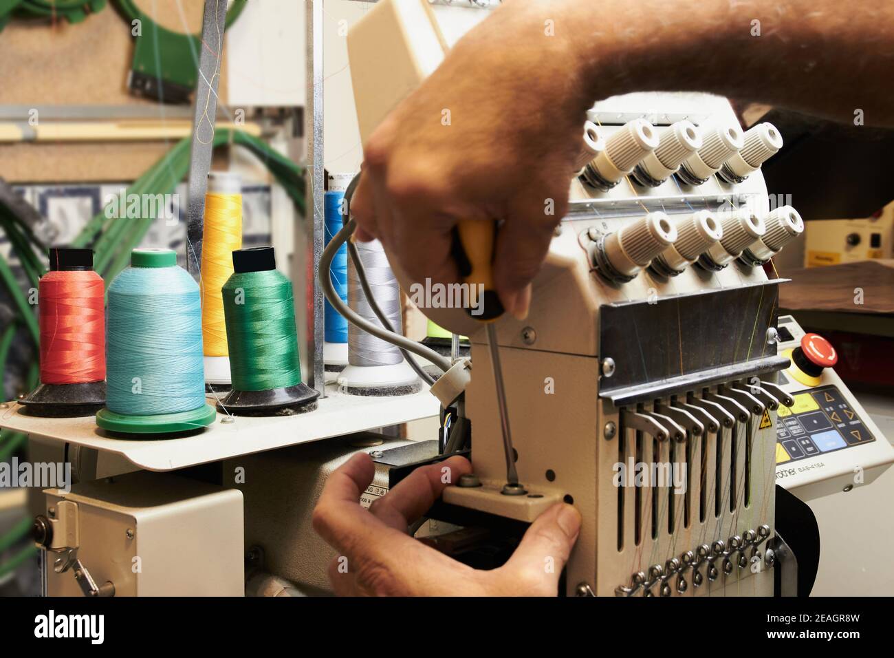 Mechanical and electrical specialist technician of embroidery machines Stock Photo