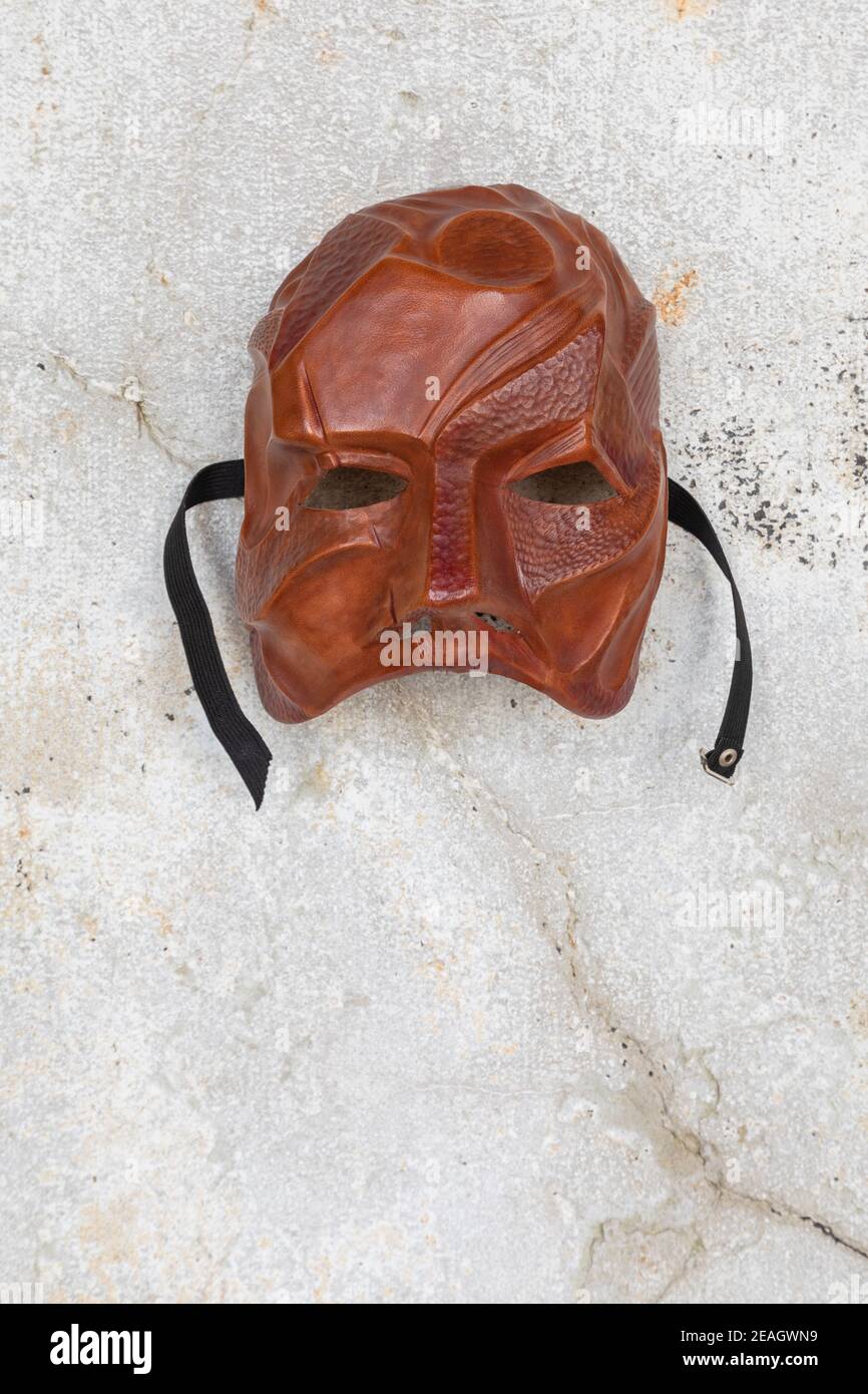Leather theatre mask made by artist Carlo Setti from Venice. Mask portrays an elemental stone warrior with a rugged and scarred face. Stock Photo