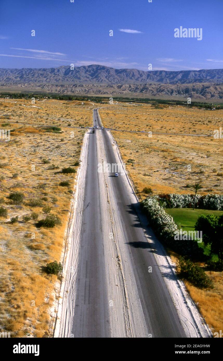 Aerial view of road leaving town and heading out through the Palm Desert in Southern California Stock Photo