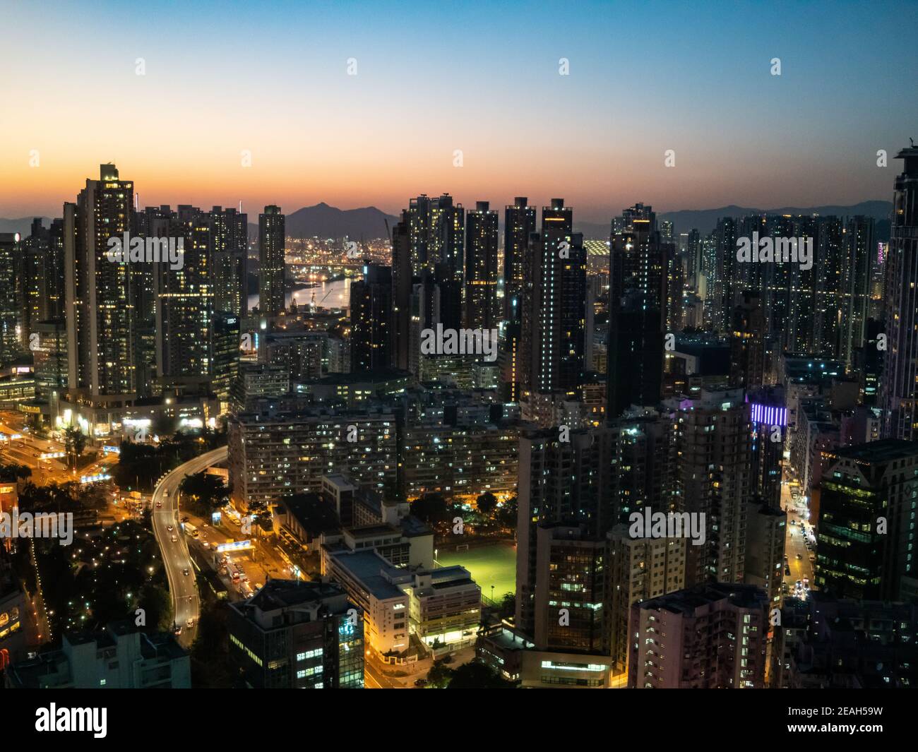 Lit up buildings in West Kowloon Hong Kong viewed against early evening sky Stock Photo