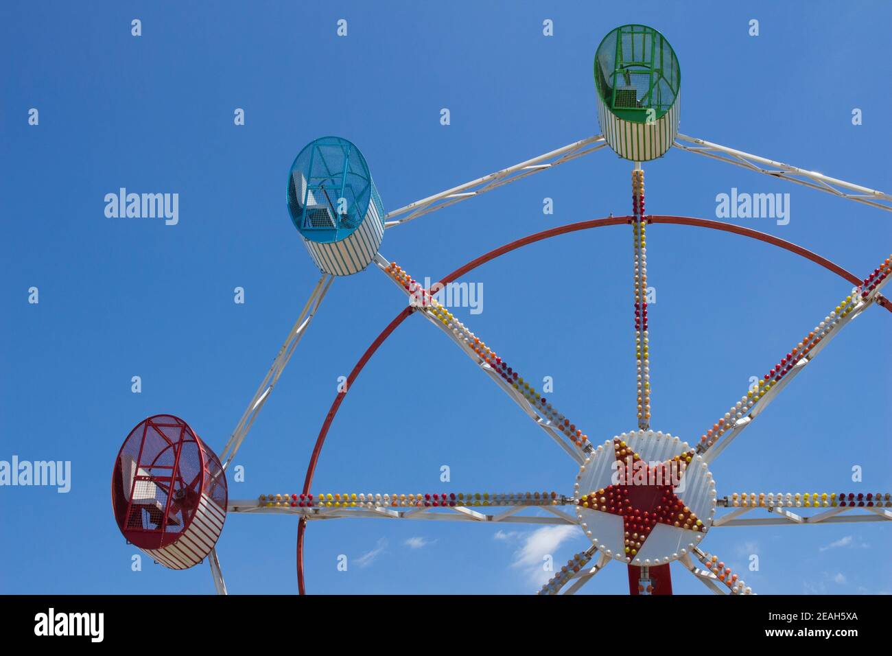 Big Wheel with three seats on blue sky summer day at an amusement park. Stock Photo
