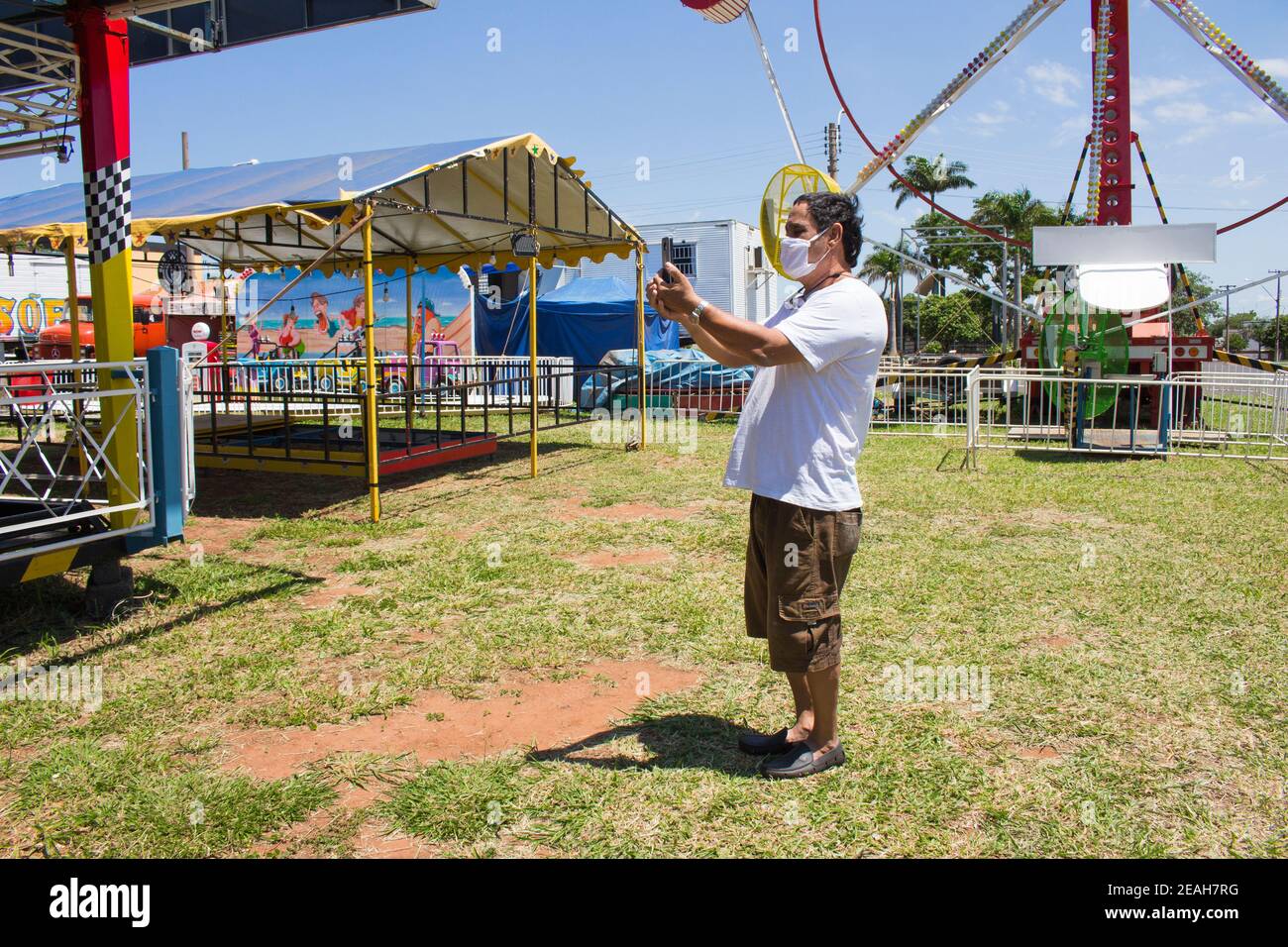 Ibitinga, SP, Brazil - Feb 07 2021: Man with mask taking a selfie picture at an amusement park; Brazilian countryside Stock Photo