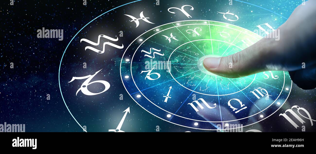 Astrological zodiac signs inside of horoscope circle. Man or Woman touching screen Zodiac signs hologram. Astrology concept. Stock Photo