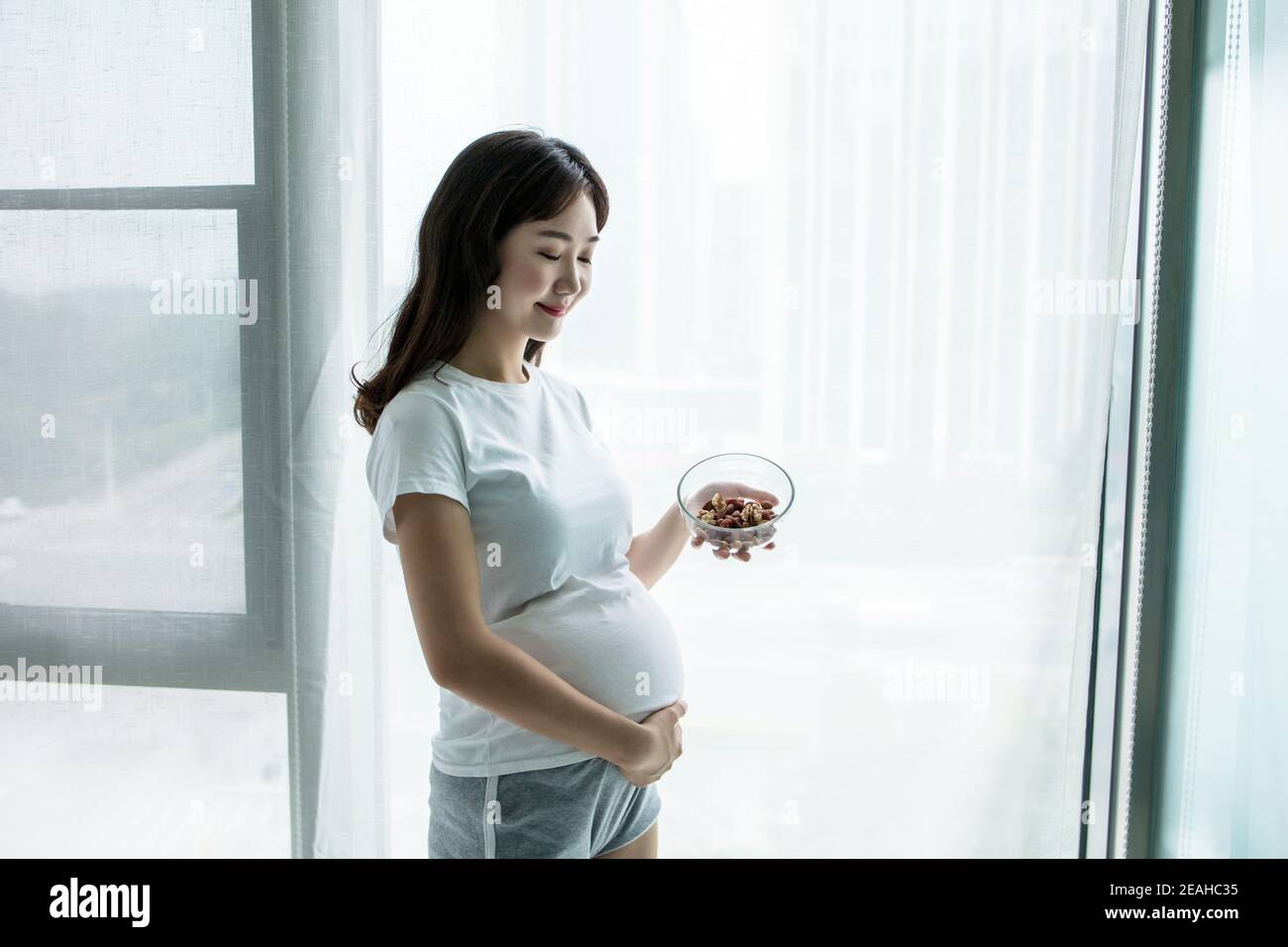Pregnant woman eating nuts hires stock photography and images Alamy