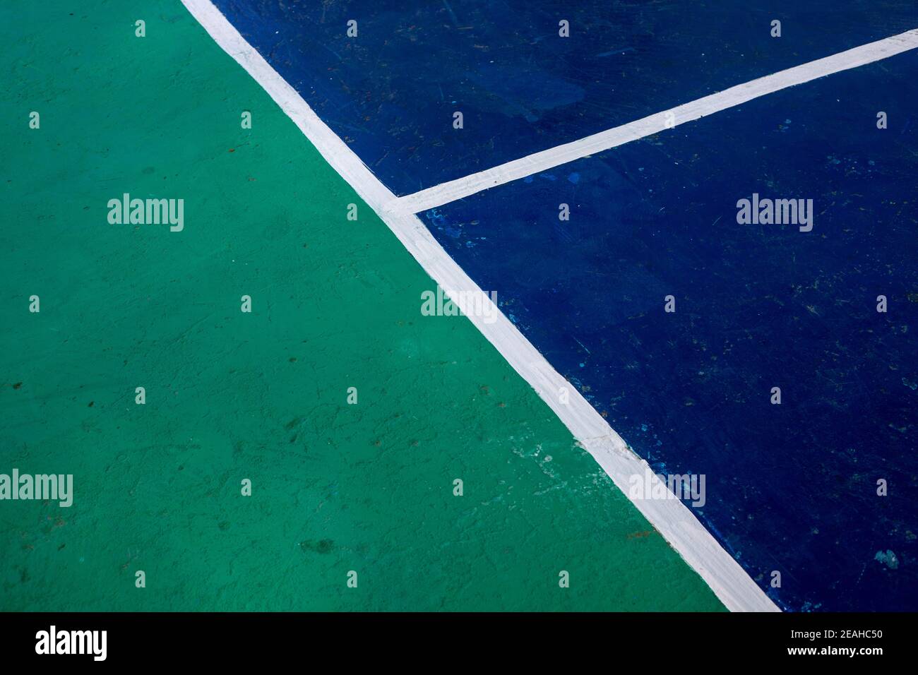 Sport field with color blocks and white line marks, perspective view photo. Tennis court cover in green and blue colors. Business competition concept. Stock Photo