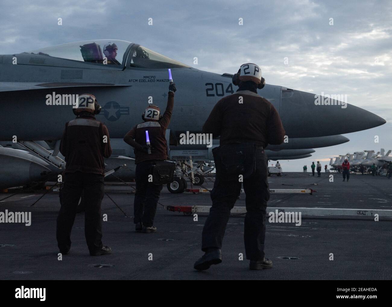 Handout photo of U.S. Sailors signal the pilot of an F/A-18E Super Hornet, assigned to the “Tomcatters” of Strike Fighter Squadron (VFA) 31, while conducting dual-carrier operations with the Nimitz Carrier Strike Group in the South China Sea February 9, 2021. Two US Navy aircraft carrier strike groups began operations in the disputed waters of the South China Sea on Tuesday, the latest show of naval capabilities by the Biden administration as it pledges to stand firm against Chinese territorial claims.The carriers USS Theodore Roosevelt and USS Nimitz and their accompanying guided-missile crui Stock Photo