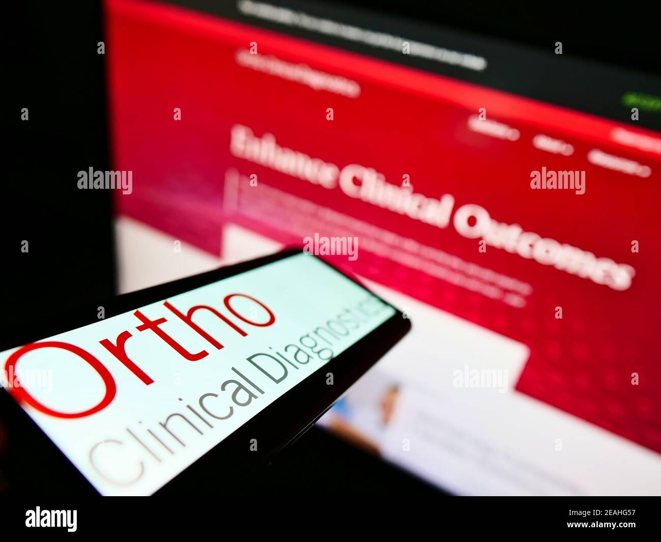 Cellphone with logo of US medical diagnostics company Ortho Clinical Diagnostics on screen in front of website. Focus on center of phone display. Stock Photo