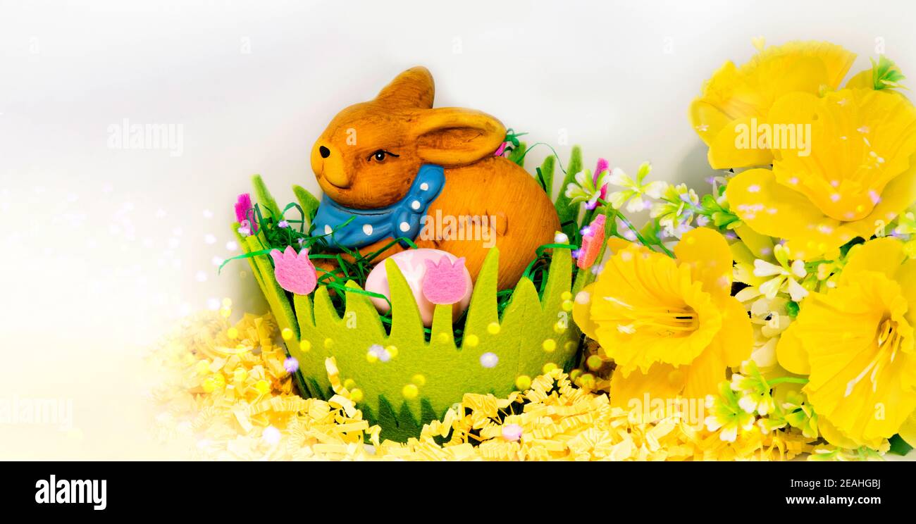 Easter bunny with eggs in a green easter basket on white background ...