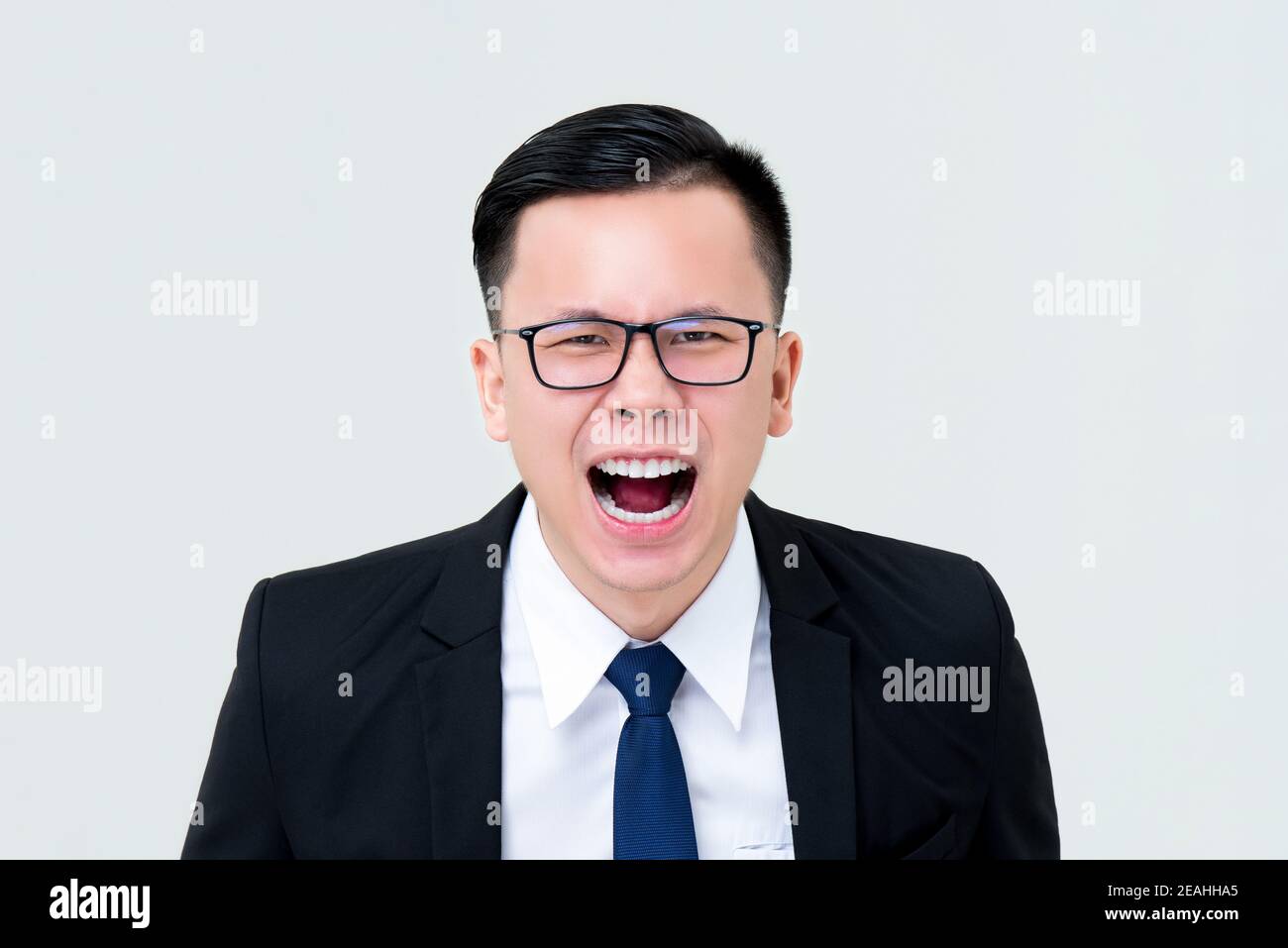 Angry Asian businessman screaming isolated on gray background ...