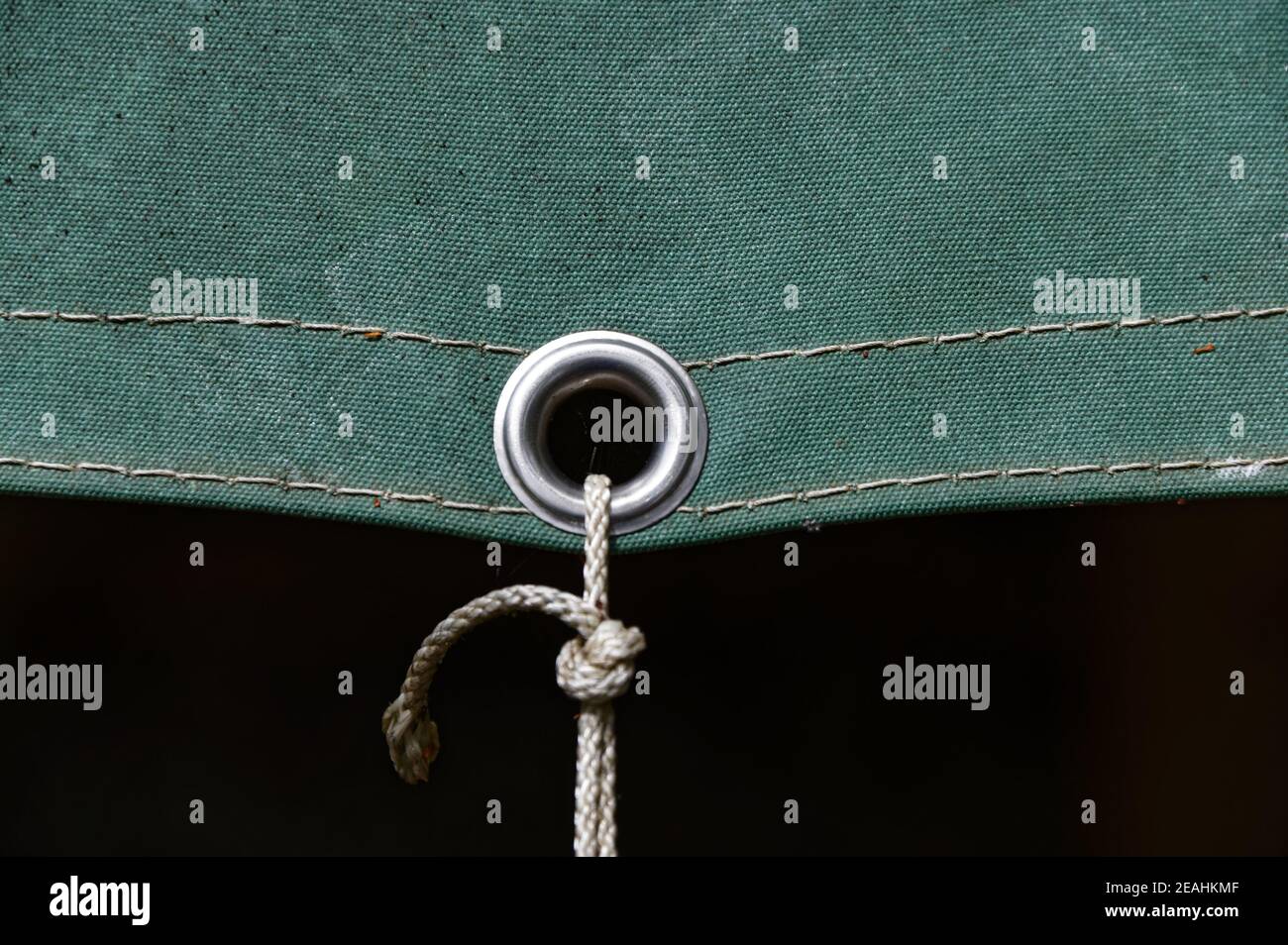 A metal eyelet in a tarpaulin keeps it securely fastened Stock Photo