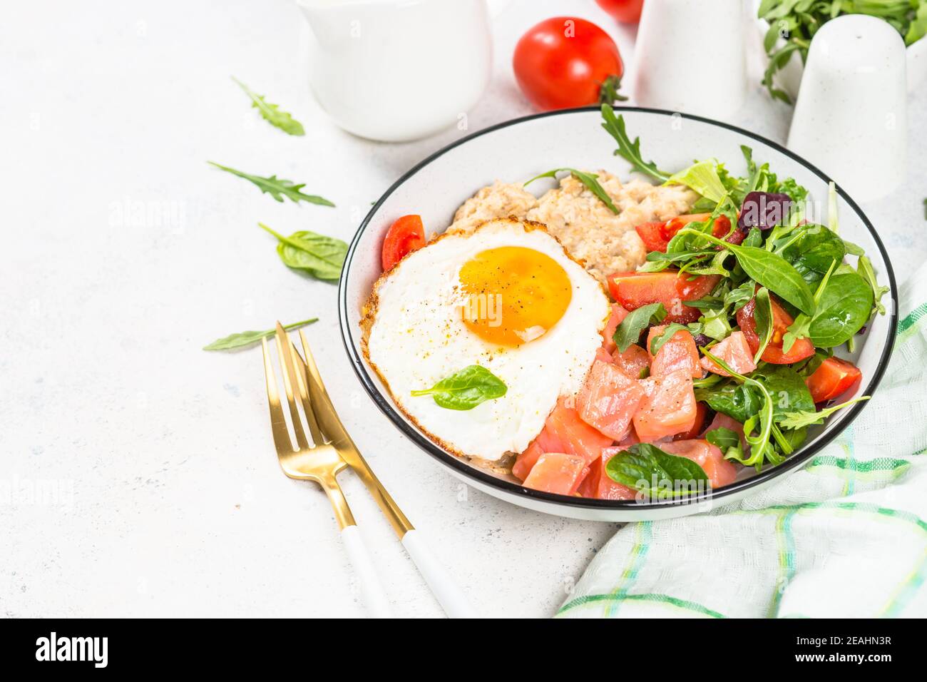 Savory breakfast with oatmeal, salmon and salad. Stock Photo