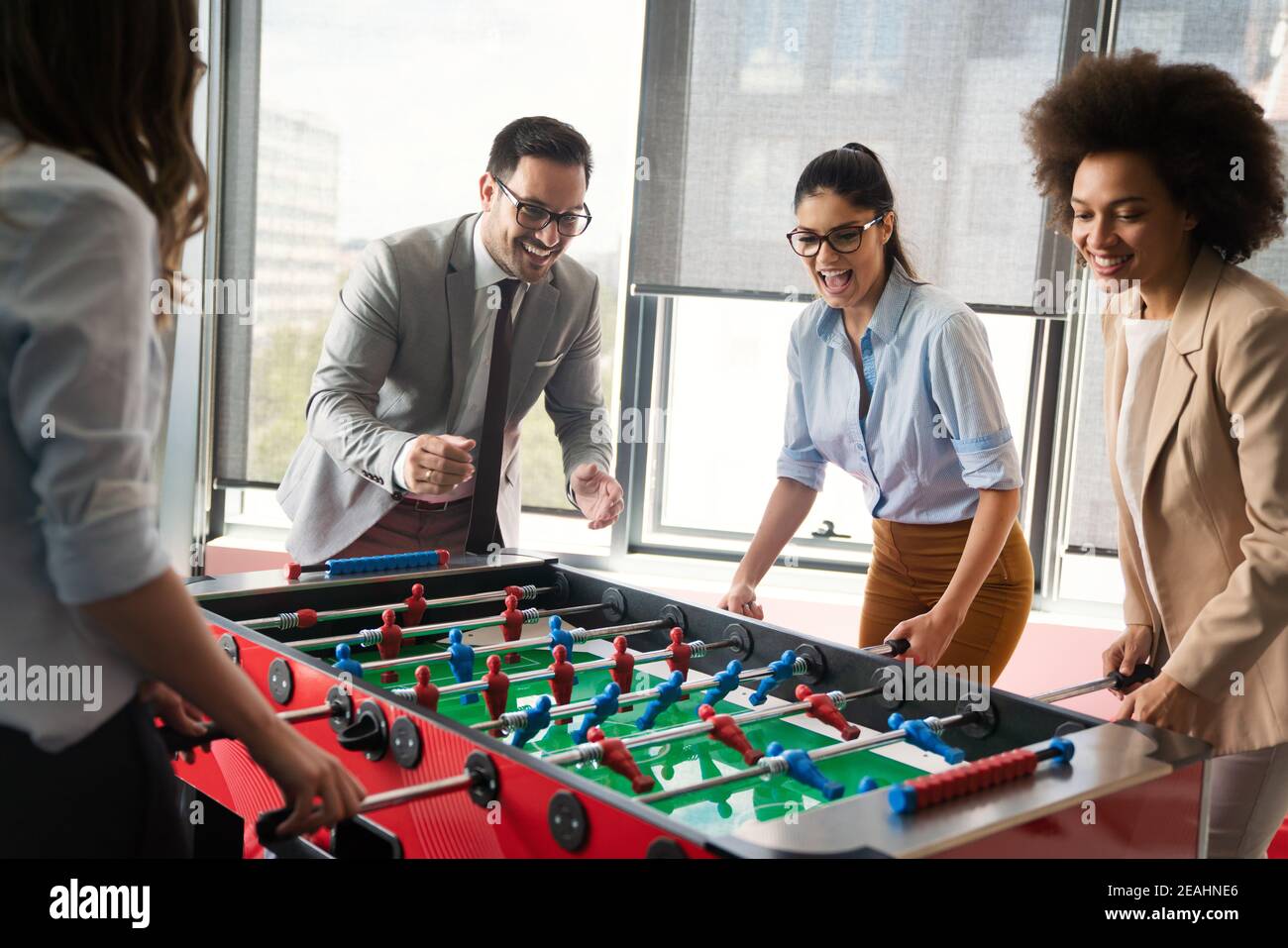 Excited diverse employees enjoying funny activity at work break