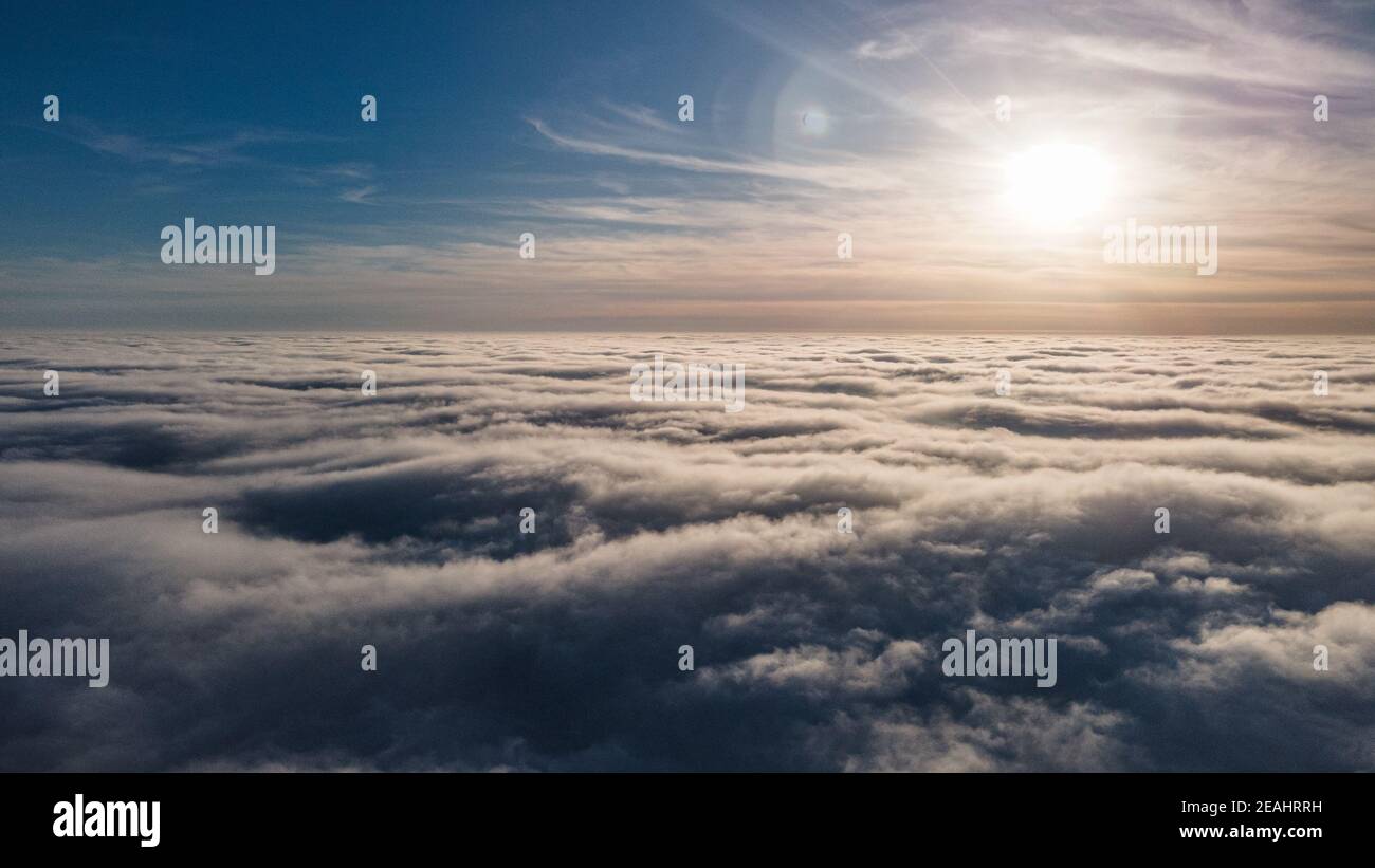 Beautiful sunset sky above clouds with dramatic light. Cabin view from airplane Stock Photo