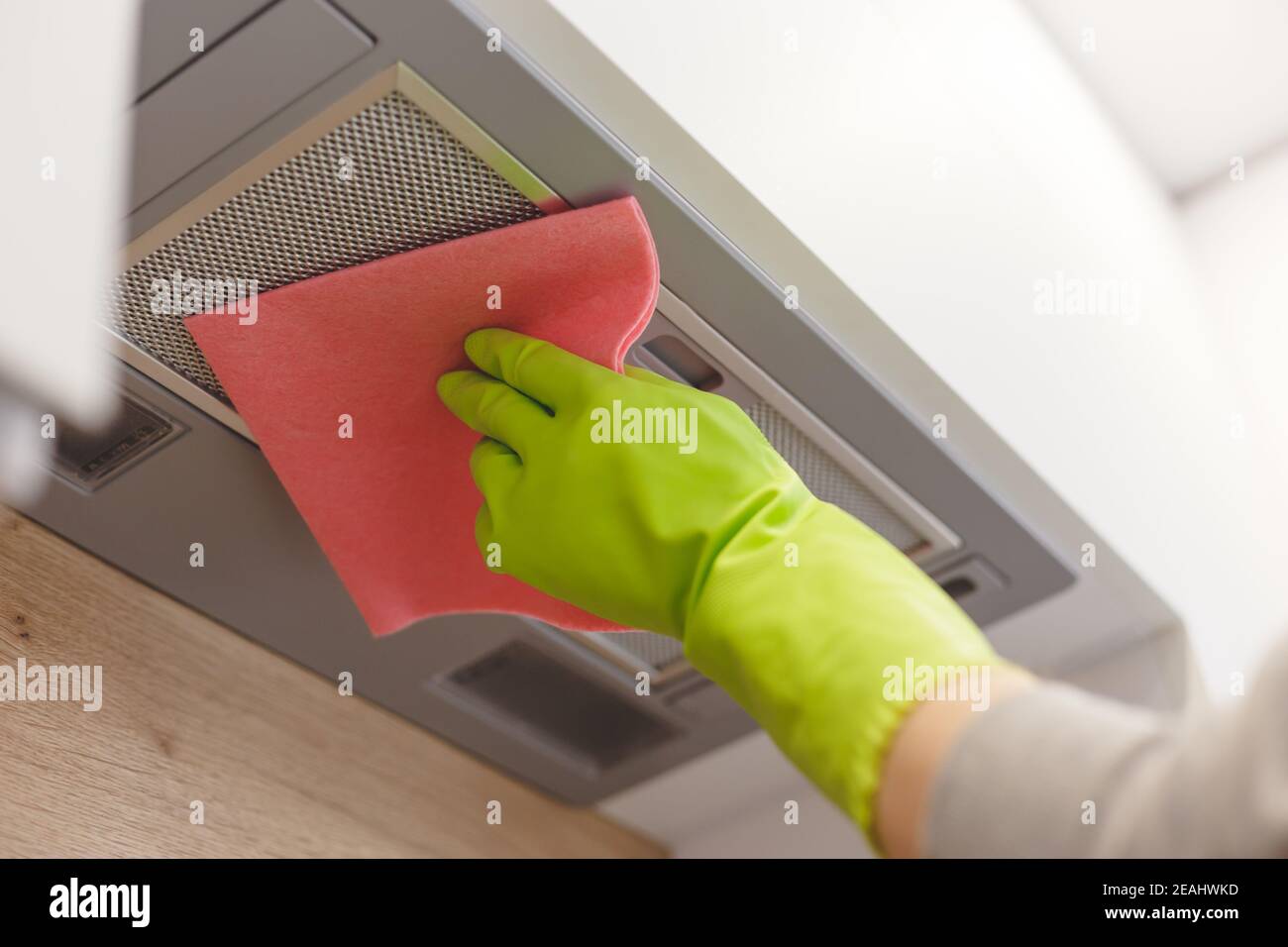 Cleaning domestic cooker hood grid with pink cloth fiber napkin Stock
