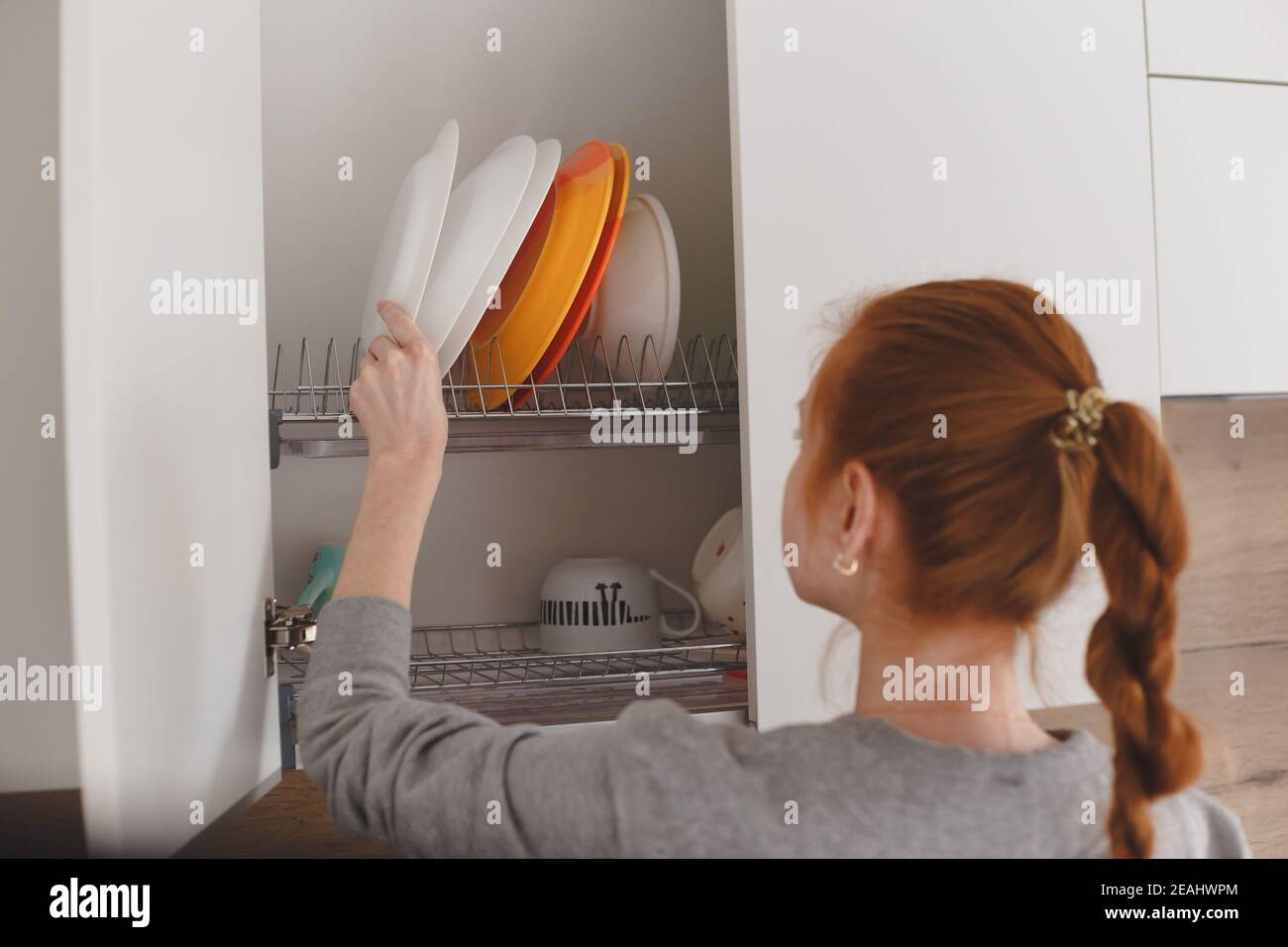 Girl opening kitchen cupboard hires stock photography and images Alamy