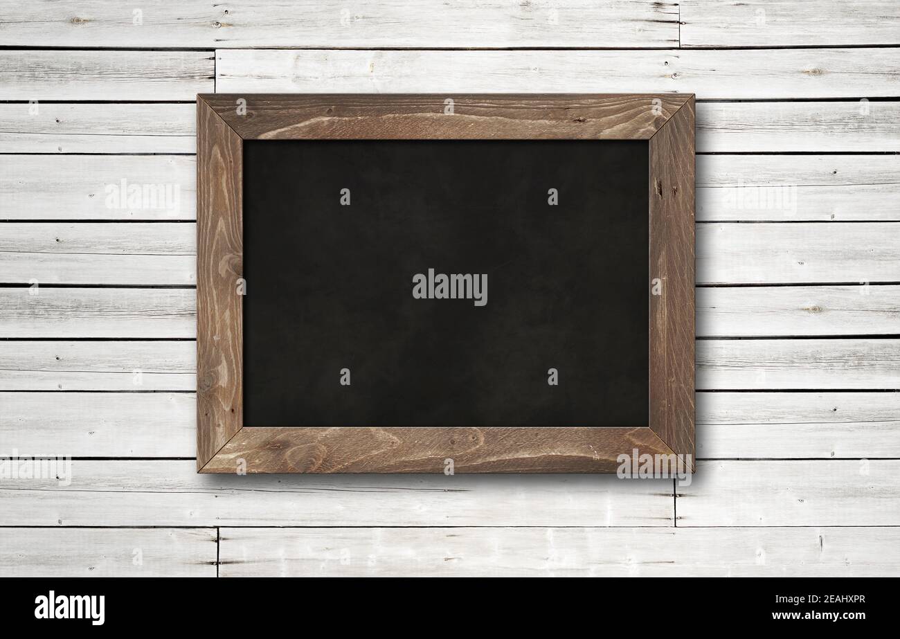 Old rustic black board isolated on a wooden background Stock Photo
