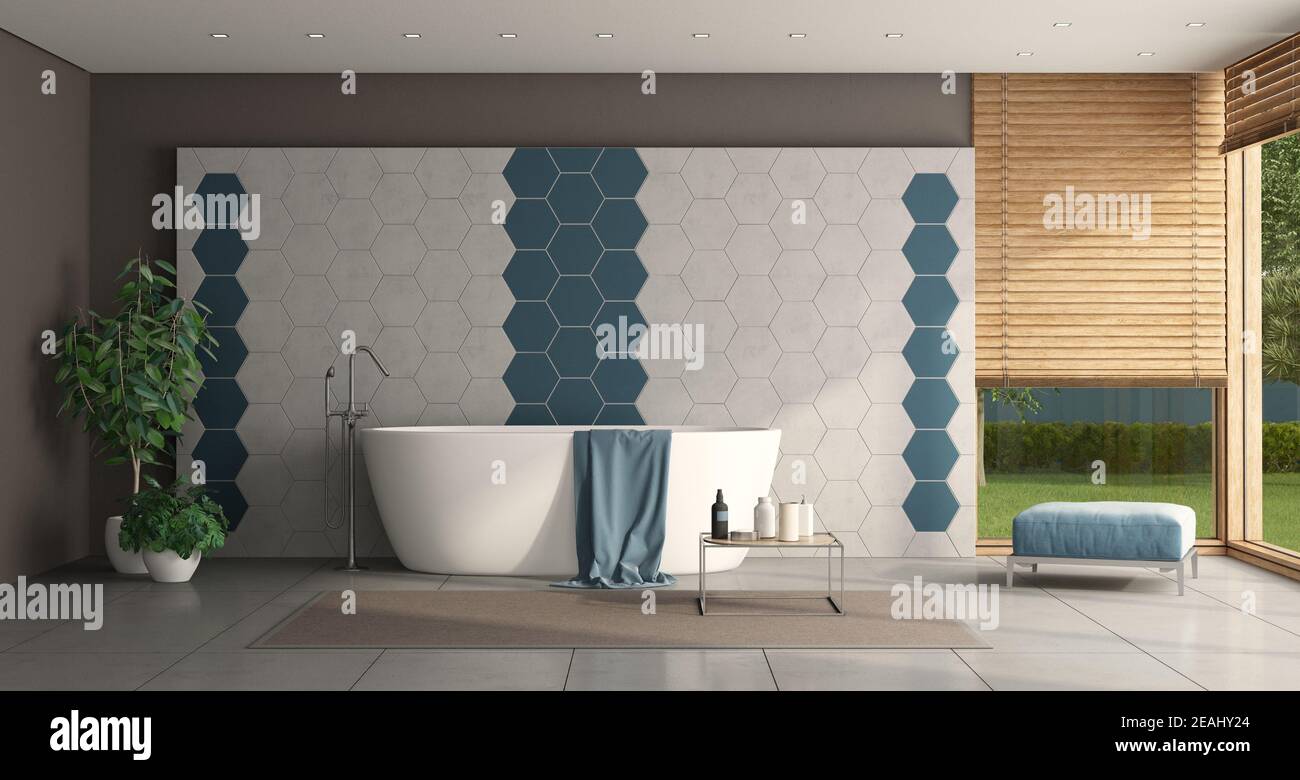 Modern bathroom with tub in front of a hexagonal tiled wall Stock Photo