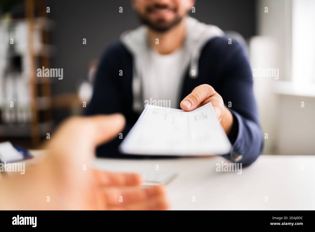 Man Giving Payroll Compensation Paycheck Stock Photo
