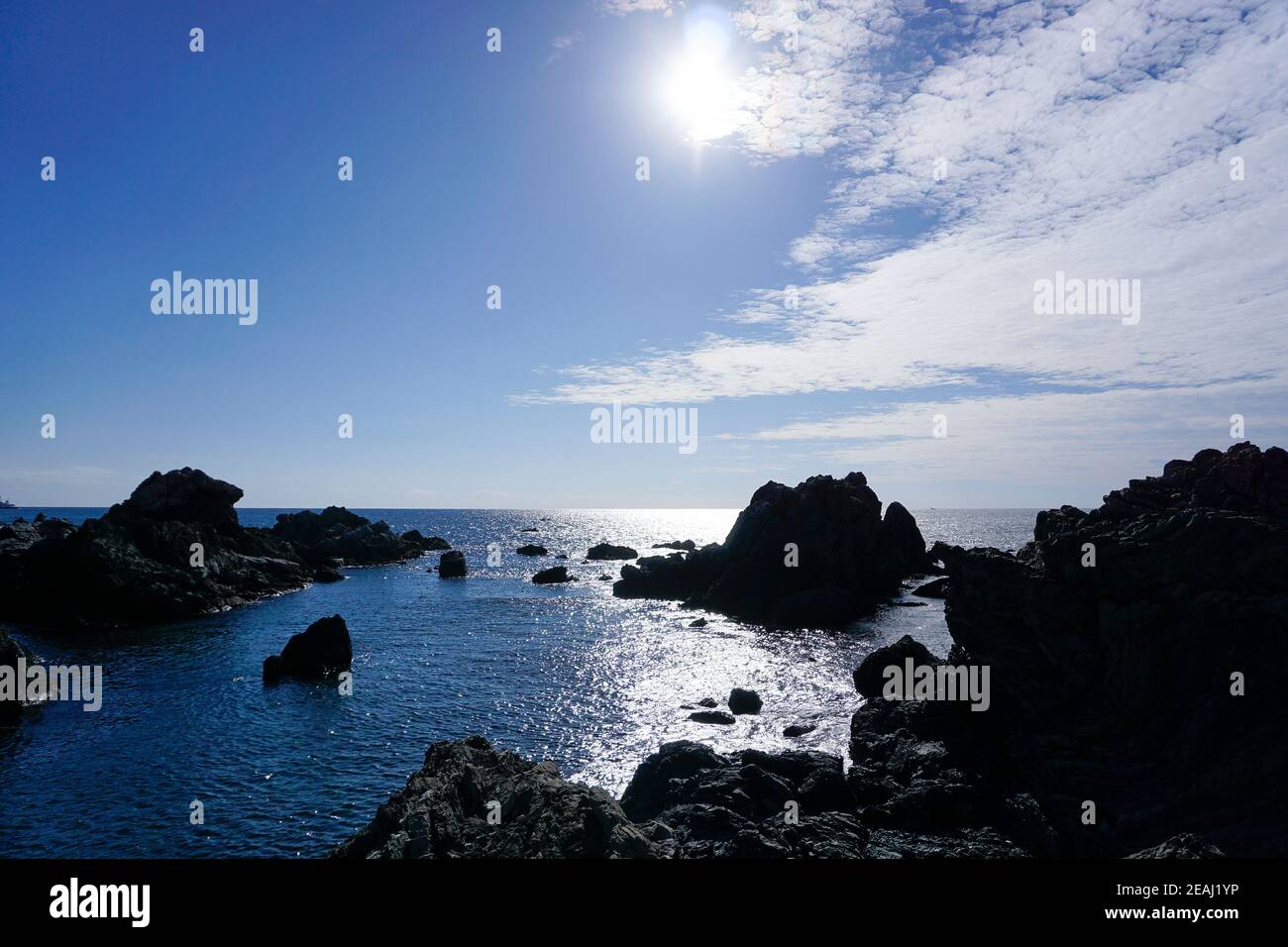 Blue sky and rocky shore Stock Photo - Alamy