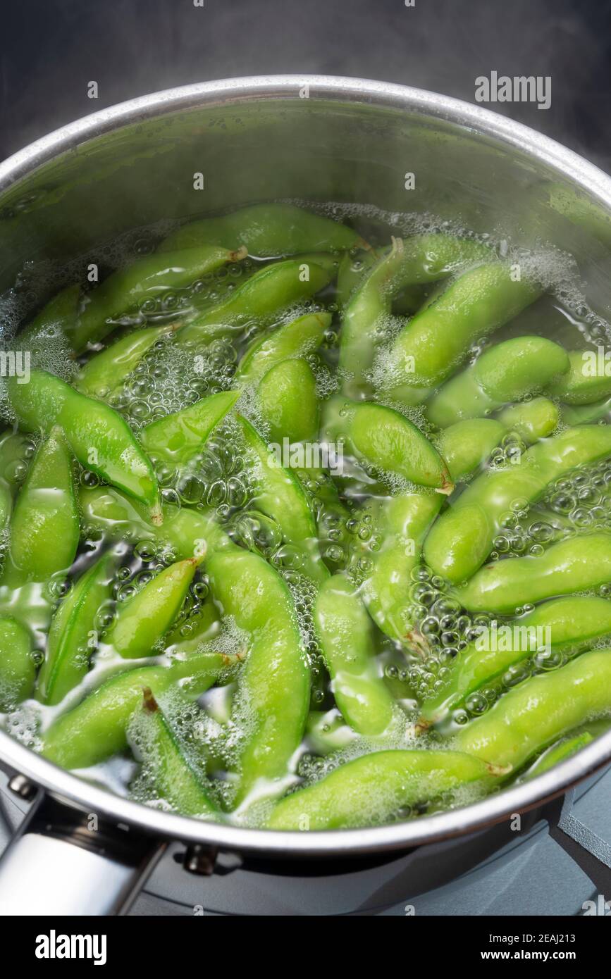 The edamame is being cooked in a pot. Stock Photo