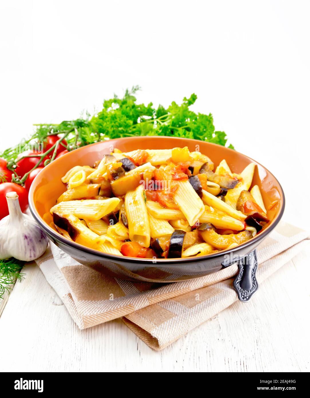 Pasta penne with eggplant and tomatoes on napkin Stock Photo