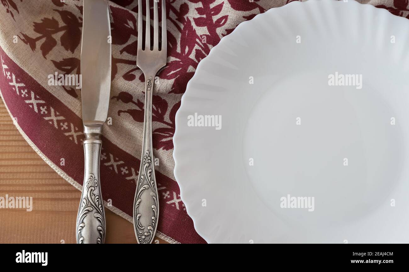 A white empty plate on a linen napkin Stock Photo