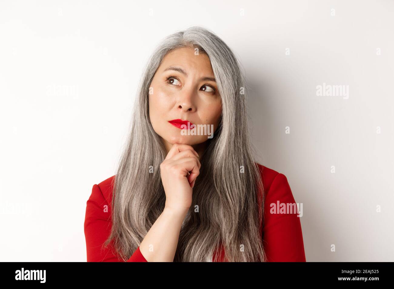 Close up of thoughtful asian business woman looking at upper left