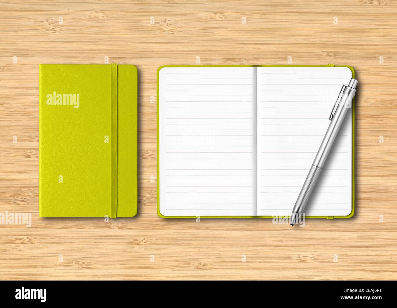Lime green closed and open lined notebooks with a pen on wooden background Stock Photo