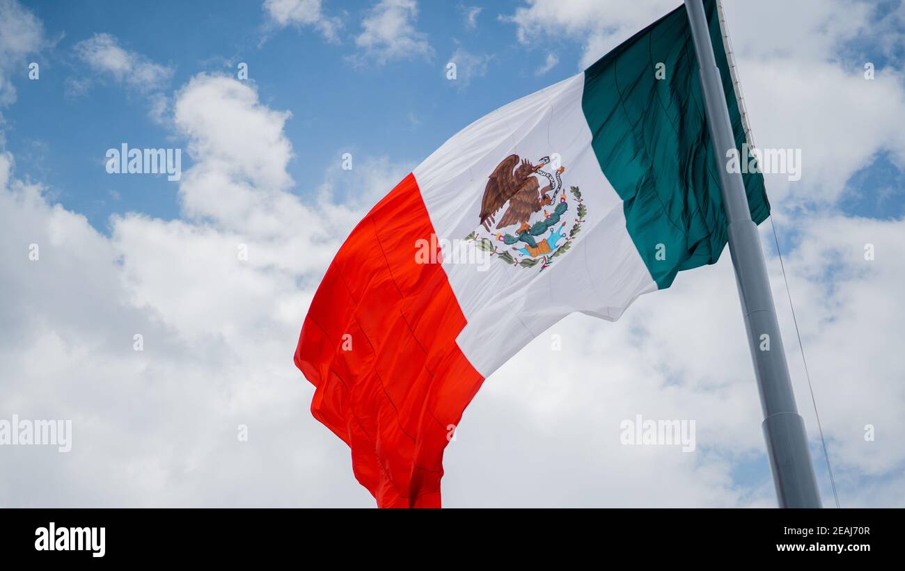 Mexican Flag Waving in the Wind Under a Cloudy Sky Stock Photo