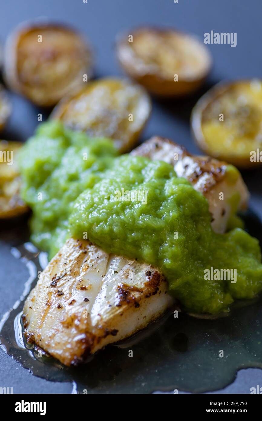 frilled cod fish with green asparagus pea sauce and fried potatoes Stock Photo