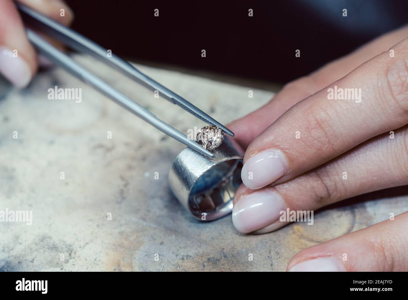 Jeweler setting a precious stone with pincers on a ring Stock Photo Alamy